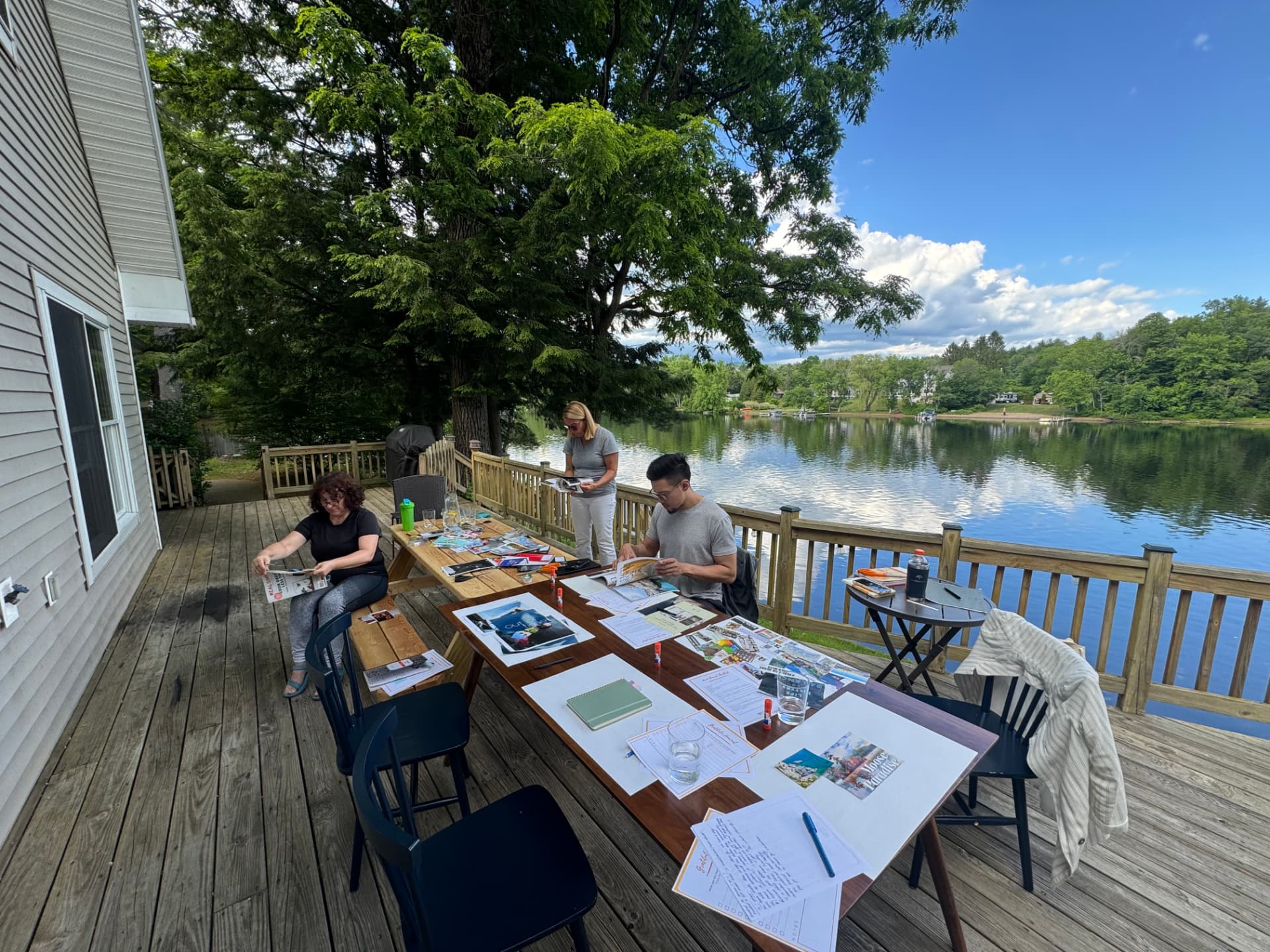 A small group working on a collage workshop at tables on the lakeside deck