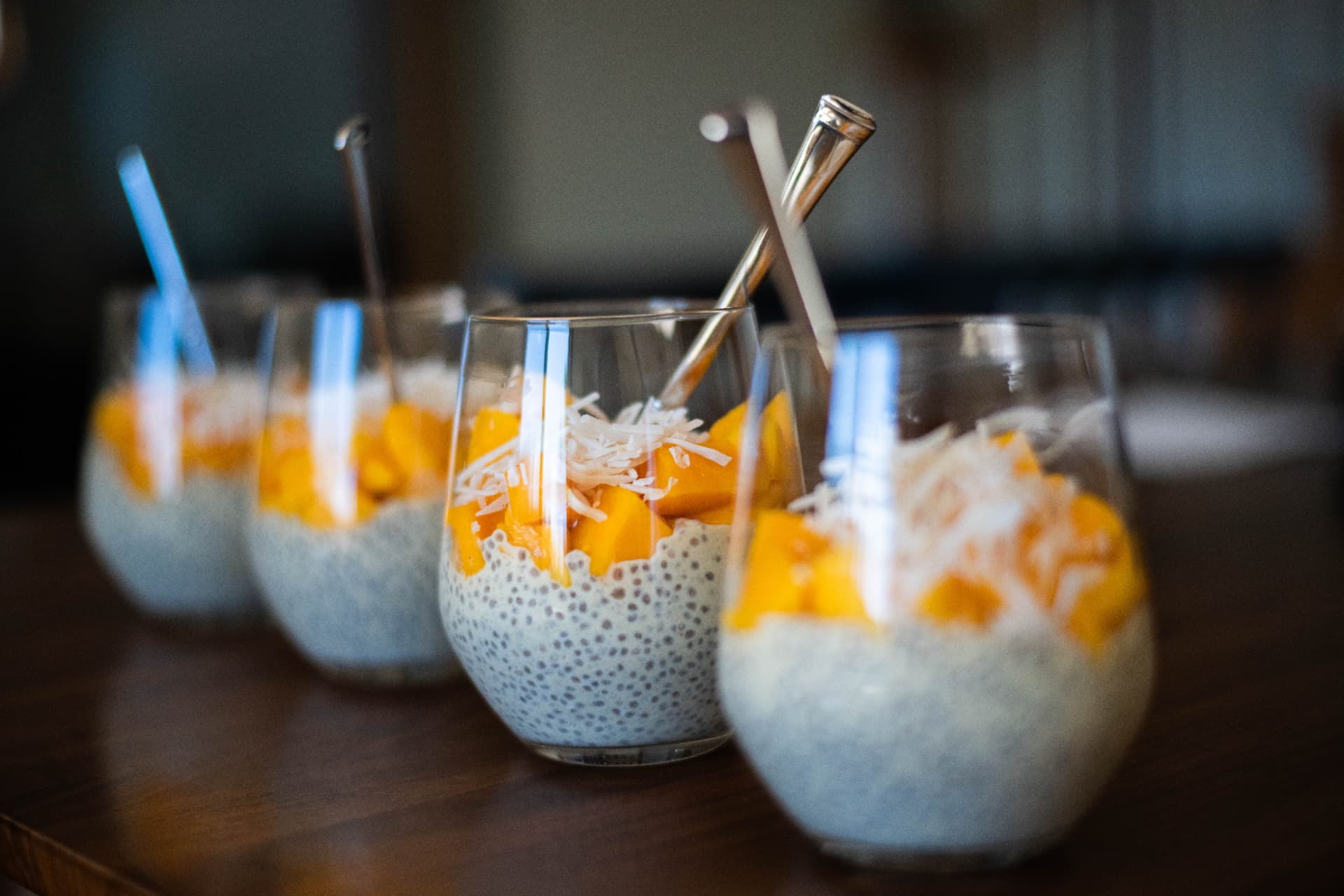 Glasses of chia pudding topped with mango and coconut